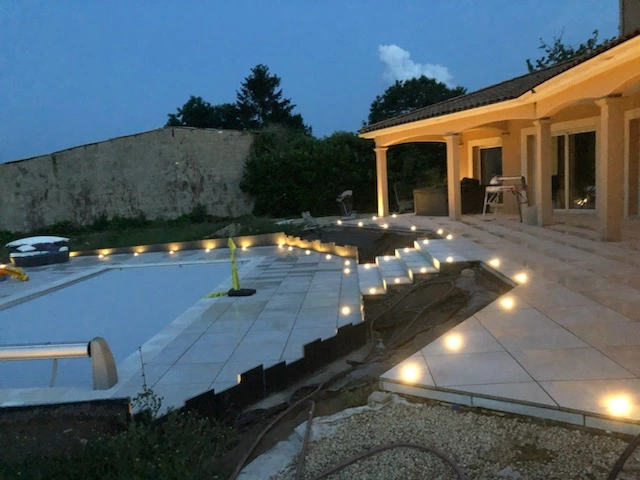 Aménagement autour de la piscine à Saint-Martin-la-Rivière photographié de nuit